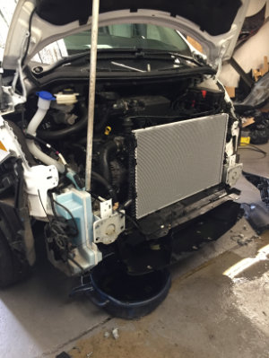 Complete removal of a van's front cover showing the radiator, and parts of the engine.